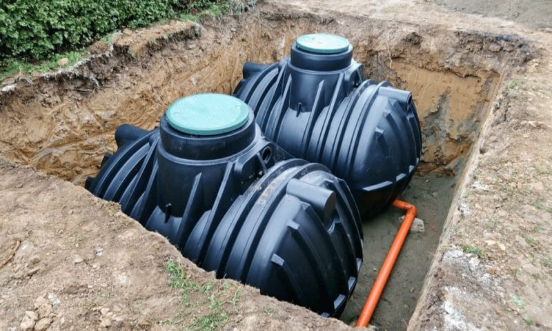 In-ground water containment system large black containers to be buried.