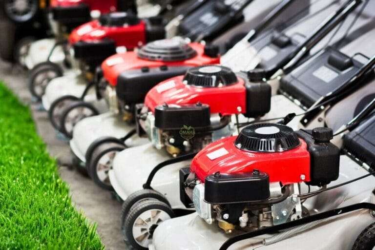 A row of red and black gas-powered lawn mowers, perfect for maintaining your lawn, on display next to artificial green turf. Remember, new lawn mower blades need sharpening for the best performance. omahagardener.com Discover the truth about whether new lawn mower blades need sharpening before use. Learn expert tips and ensure your mower is ready for the season with our in-depth guide.