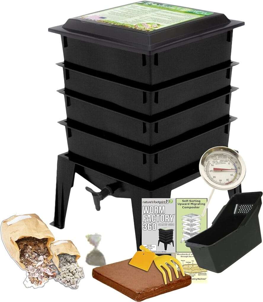 A black multi-tiered worm composter designed for urban composting includes a thermometer, a bag of worm bedding, a small block of coconut coir, a plastic bin, yellow scraper, and an instruction manual. omahagardener.com